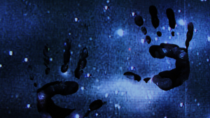 Blurry bluish-black image of stars or lights at night seen through a transparent screen marked with smeared human handprints.