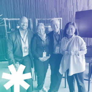 A blue-tinted image of four smiling people standing grouped closely together: Chris Lewis, Catherine Stihler, Brewster Kahle, and Wendy Hanamura, with a white Movement for a Better Internet logo in the bottom left corner.