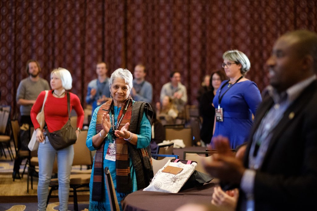 A group of people standing in a room during a CC event.